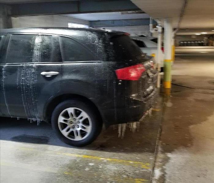 Icicles hanging from vehicle in a parking garage.  